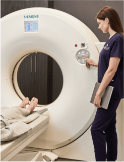sollis employee operating MRI machine as patient lays on MRI bed awaiting exam