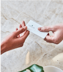 sollis business card being exchanged between two hands over a marble background